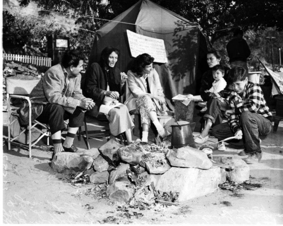 A displaced Hispanic camping outside after their home was destroyed.