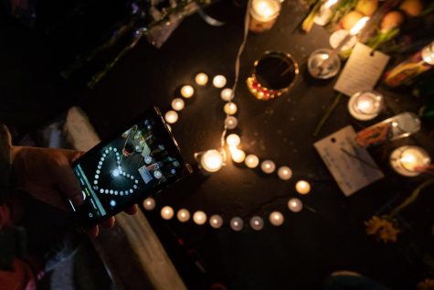 A mourner takes a photo of candles during a candlelight vigil at the Star Ballroom Dance Studio In Monterey Park. 