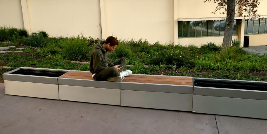 Studio arts major Shannon Turner sitting on the newly installed benches around campus.