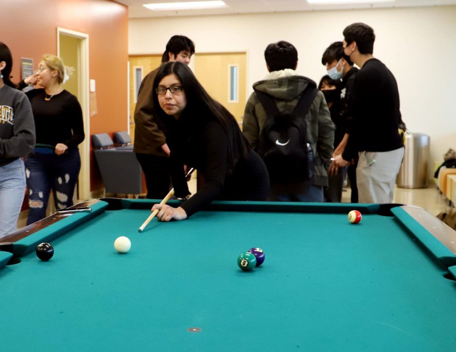 Brenda Rodriguez playing pool in the USU game room located on the second floor. Photo by Victoria Ivie.
