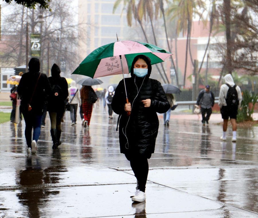 Cesia Rios, a psychology major, trying to avoid puddles on the Cal State LA campus. Photo by Victoria Ivie.