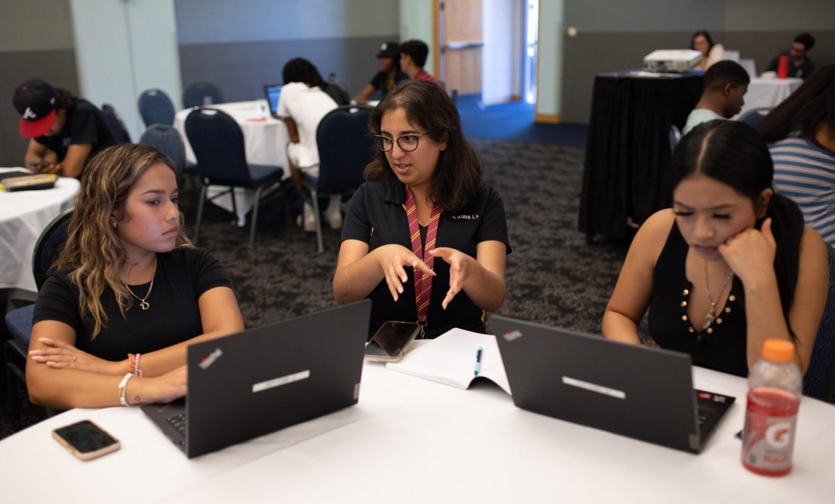 Orientation leader Sonrisa Lopez assists incoming freshman Destiny Paredes-Flores (left) and Alma Santiago during the new student orientation at the Golden Eagle Ballroom on Friday, August 19, 2023.