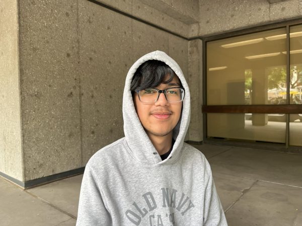 A photo of a college student with glasses and a gray hoodie on.
