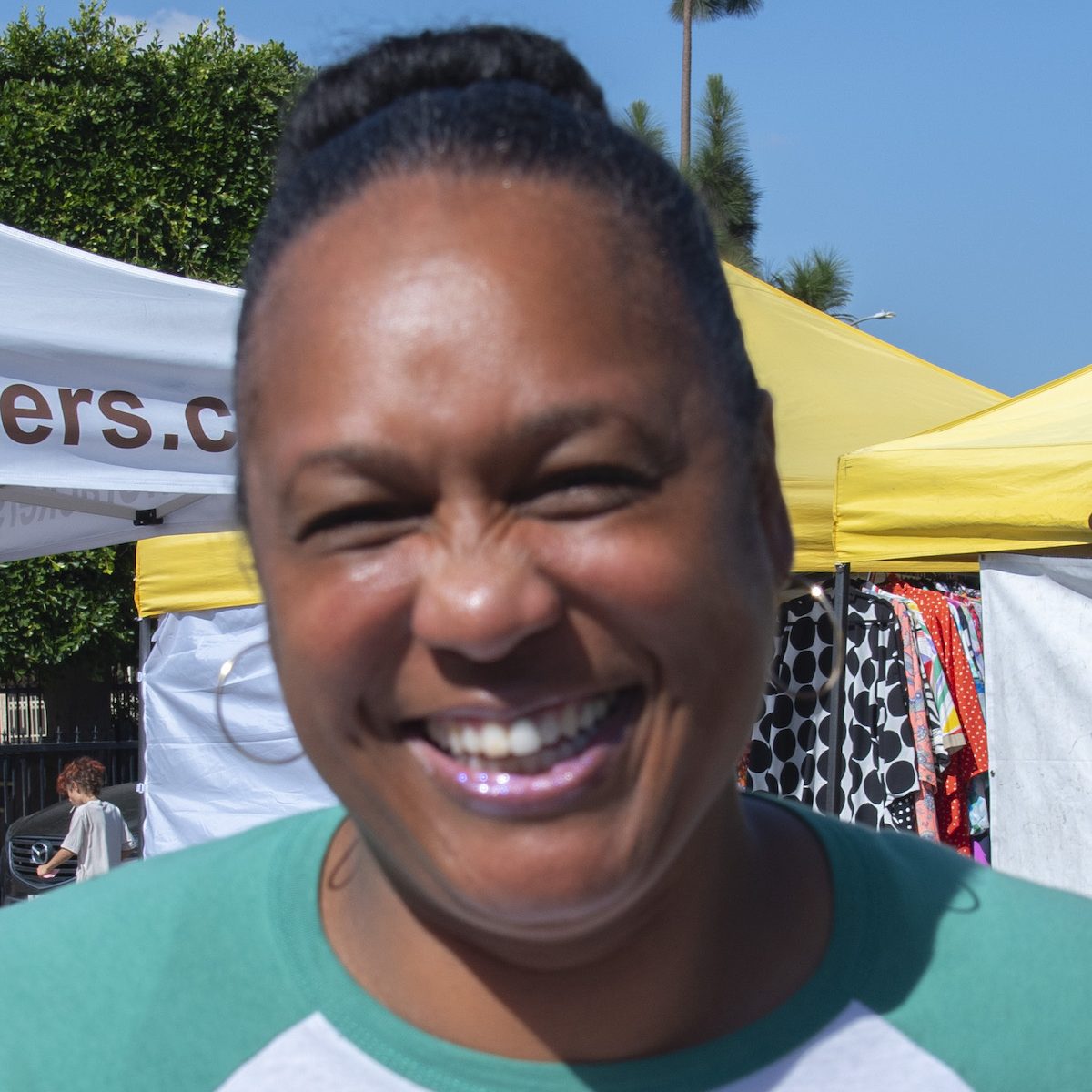 Javonne Sanders, creator of the salad company, "Toss It Up" poses next to her booth at the Wellington Square Farmers Market in South Los Angeles. Photo by Tristan Longwell.