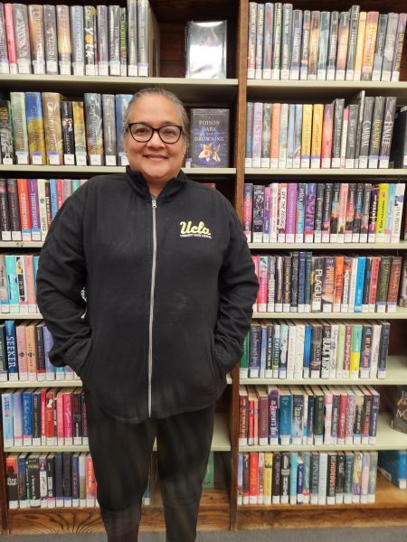 UCLA alumna Laura Rodriguez poses for the camera while inside the library.