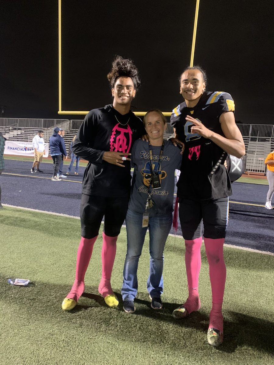 Warren High School Athletics Director Samantha Miyahara posses with two Warren players in Fall 2022.