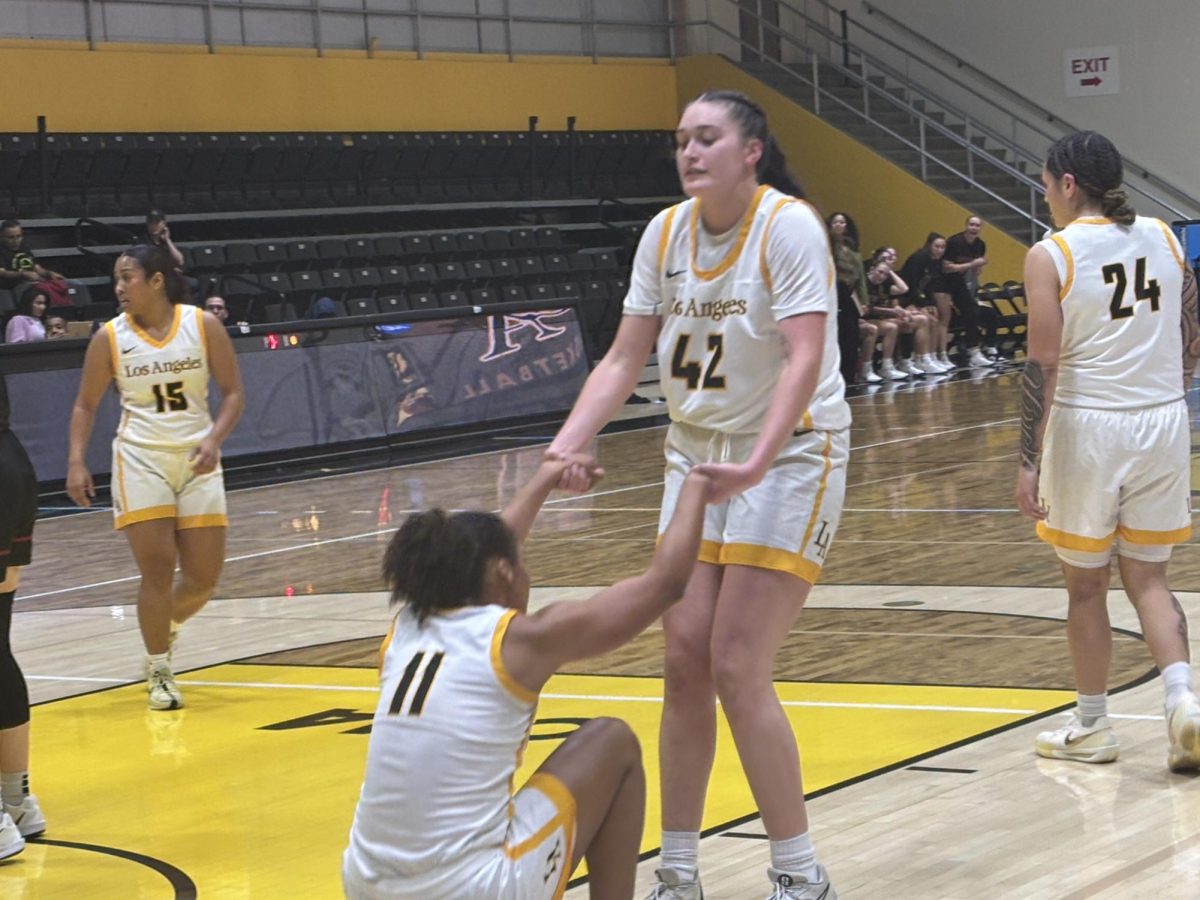 Amaya Fuentes (42) picking up her teammate Lily Buggs (11) during Cal State LA's women's basketball game against Central Washington on Thursday, Dec. 19, 2024.