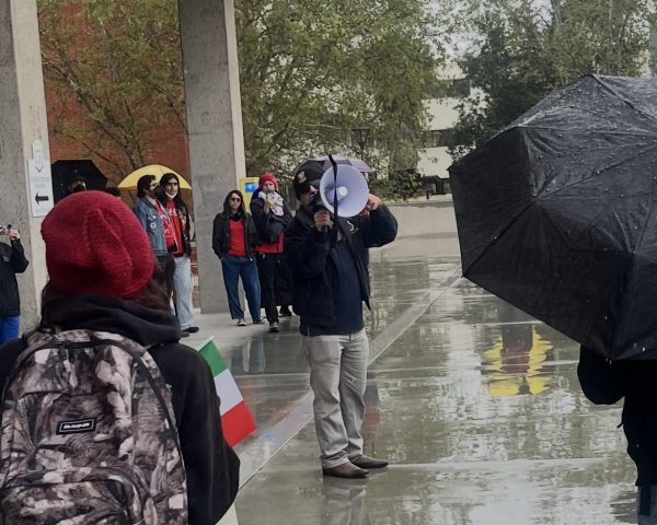 Ali Tweini, a political action committee member speaks to students, faculty, and staff union members at a protest about layoffs at Cal State LA. Photo by Kara Alexander.