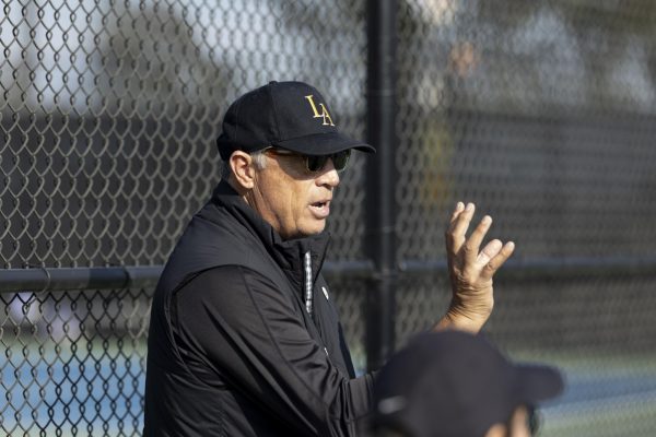 Head coach Richard Gallien talking strategy with his players on the court during a match. (Courtesy of smugmug)
