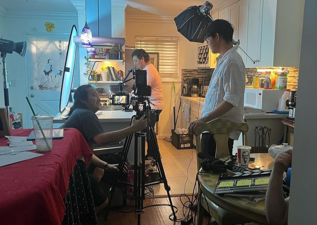 Minh Tran (right) looks over at the camera as a scene is being filmed. Photo courtesy of Minh Tran.