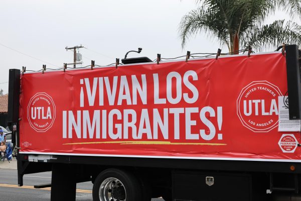 A poster during the parade that translates to "Immigrant Lives!"