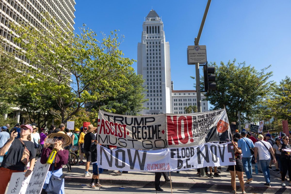 No Kings protestors flood the crosswalk between the Vietnam memorial and Grand Park. Oct. 18, 2025.