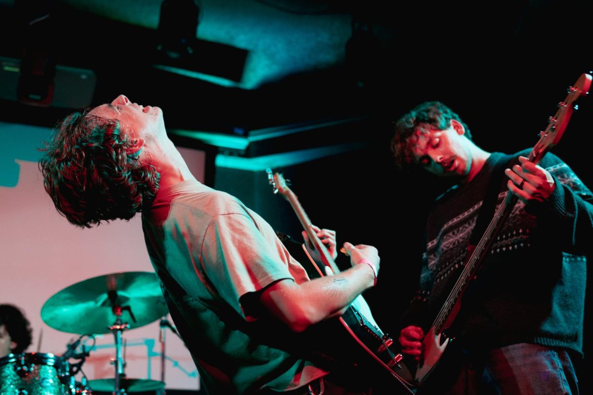 Members of the band Sleeping with Socks On during an energetic moment on stage.